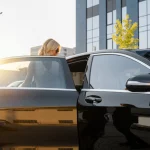 Chauffeur opening door of a luxury black limo in Houston