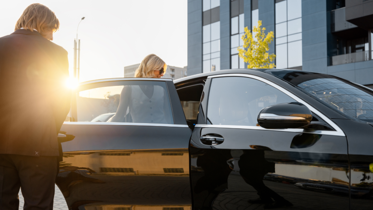 Chauffeur opening door of a luxury black limo in Houston