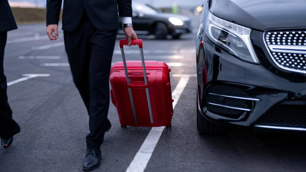 Luxury black limo waiting outside Houston airport terminal with chauffeur