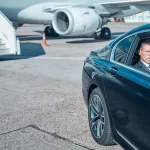 Chauffeur with black SUV at Houston airport pickup zone
