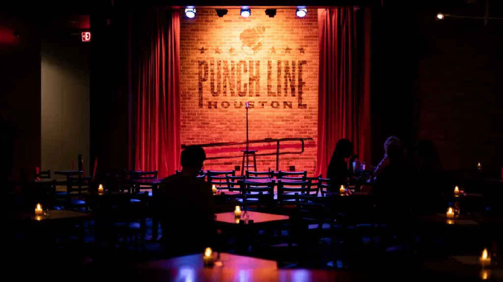 Guests arriving in a luxury SUV at Punch Line Comedy Houston at night
